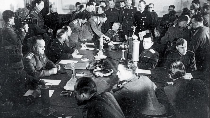 Blick in den Raum während der Unterzeichnung der Kapitulation in Berlin-Karlshorst. Links am Tisch der sowjetische Marschall Georgi Schukow, am Kopfende Generalfeldmarschall Wilhelm Keitel. Foto: dpa/Picture Alliance 