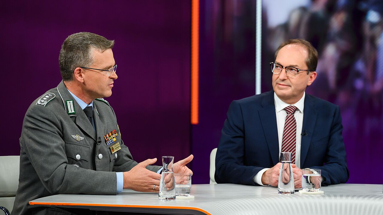 Der Bundesvorsitzende Oberst André Wüstner erklärt am Donnerstag in der politischen Talk-Show „Maybrit Illner“ im ZDF erneut, wie wichtig der personelle Aufwuchs für die Bundeswehr ist. Gast in der Sendung war auch Bundesinnenminister Alexander Dobrindt (CDU, rechts). Foto: ZDF/Jule Roehr