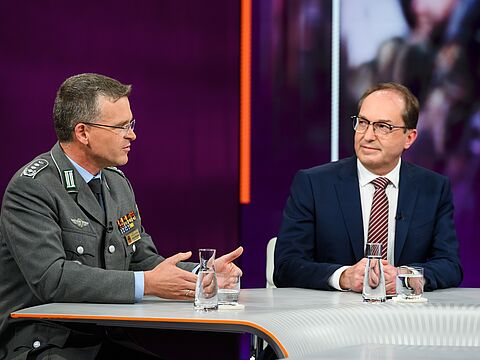 Der Bundesvorsitzende Oberst André Wüstner erklärt am Donnerstag in der politischen Talk-Show „Maybrit Illner“ im ZDF erneut, wie wichtig der personelle Aufwuchs für die Bundeswehr ist. Gast in der Sendung war auch Bundesinnenminister Alexander Dobrindt (CDU, rechts). Foto: ZDF/Jule Roehr