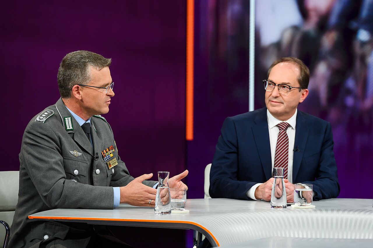 Der Bundesvorsitzende Oberst André Wüstner erklärt am Donnerstag in der politischen Talk-Show „Maybrit Illner“ im ZDF erneut, wie wichtig der personelle Aufwuchs für die Bundeswehr ist. Gast in der Sendung war auch Bundesinnenminister Alexander Dobrindt (CDU, rechts). Foto: ZDF/Jule Roehr