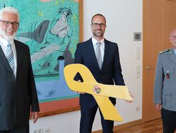 Oberstleutnant a.D. Thomas Sohst (l.), Vorsitzender Landesverband West im DBwV, überreichte die Gelbe Schleife an den Chef der Staatskanzlei, Staatssekretär Clemens Hoch (Mitte). Foto: DBwV