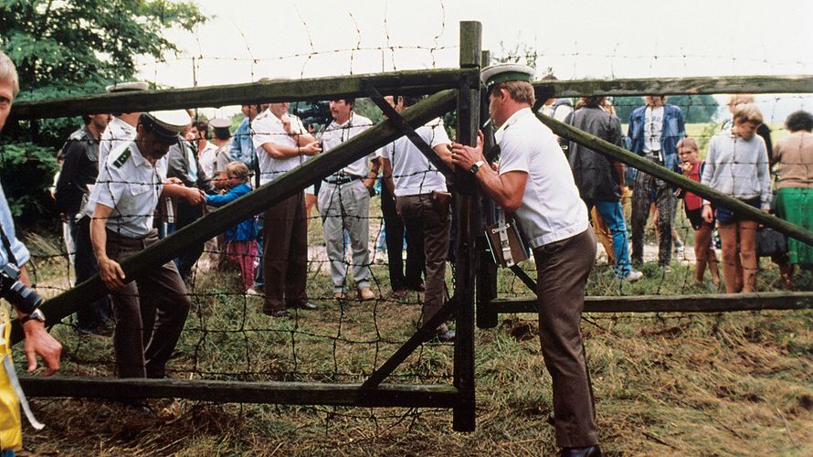 Am 19. August 1989: Österreichische Grenzbeamte öffnen ein Grenztor. Etwa 500 DDR-Bürger nutzten ein paneuropäisches Picknick an der ungarisch-österreichischen Grenze, bei dem ein Grenztor symbolisch geöffnet wurde, zur Flucht in den Westen. Foto: dpa/Votava