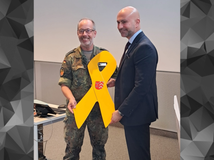 Anlässlich des 2. Veteranentages überreichte der Landesvorsitzende West, Stabsfeldwebel Volker Keil, die Gelbe Schleife an Landrat Ali Dogan (SPD). Foto: DBWV