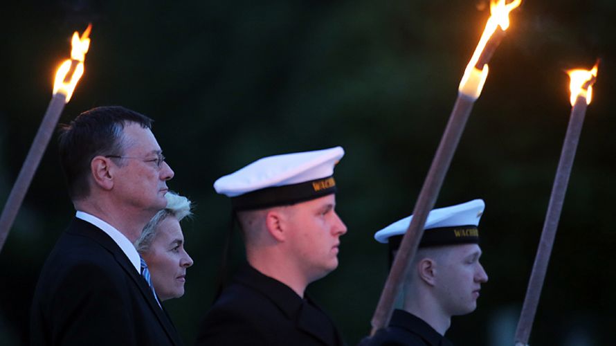 Soldaten des Wachbataillons halten Fackeln bei der Serenade zur Verabschiedung des Wehrbeauftragten des Bundestags, Hellmut Königshaus (l, FDP), mit Verteidigungsministerin Ursula von der Leyen (CDU) am 19.05.2015 im Bundesverteidigungsministerium in Berl