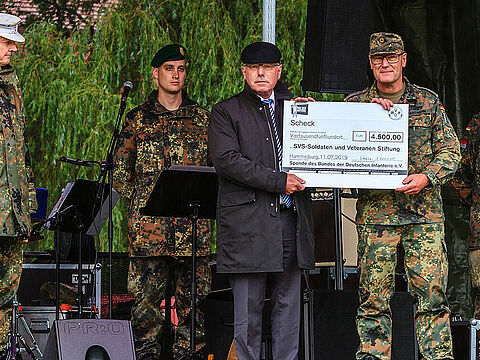Mit dem symbolischen Scheck: Brigadegeneral Michael Matz (v. l.), Generalleutnant a.D. Volker Halbauer und Hauptmann Oliver Hartmann. Foto: Schleicher