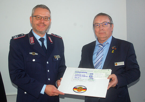 Oberstleutnant i.G. Detlef Buch (l.) nimmt von Schmelzer den Scheck für die SVS entgegen. Foto: DBwV