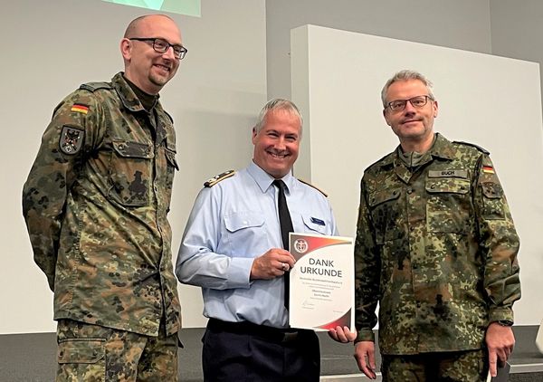 Oberstleutnant Gerrit Hecht (Mitte) wurde für sein langjähriges Engagement für den DBwV mit einer Dankurkunde geehrt, welche durch Oberstleutnant i.G. Dr. Detlef Buch (r) und den Bezirksvorsitzenden Berlin/Brandenburg, Hauptmann Christian Weber überreicht wurde. Foto: Marius Berensmann