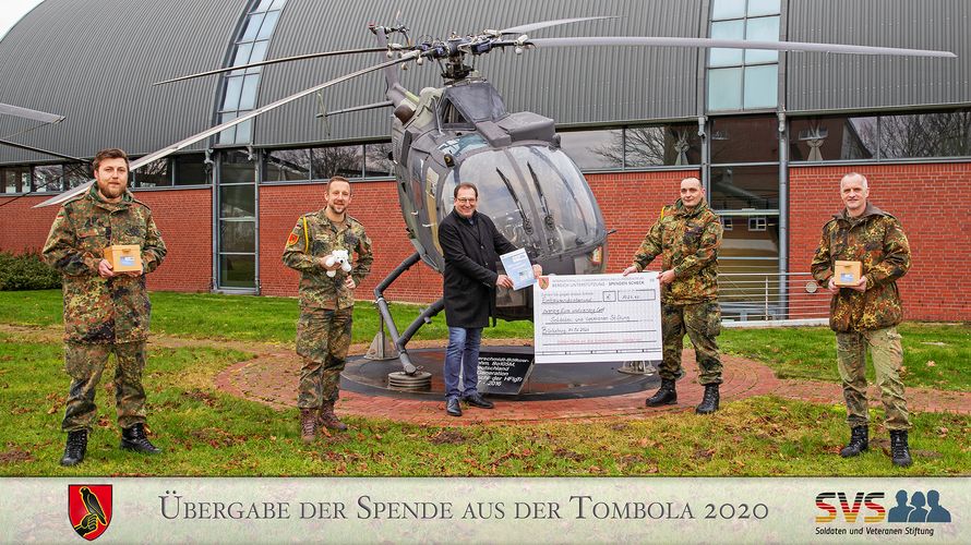 Oberstabsfeldwebel a.D. Rüdiger Neser nimmt den Spendenscheck des Bereichs Unterstützung des Internationalen Hubschrauberausbildungszentrums dankend entgegen. Foto: Alexander Bozic 
