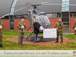 Oberstabsfeldwebel a.D. Rüdiger Neser nimmt den Spendenscheck des Bereichs Unterstützung des Internationalen Hubschrauberausbildungszentrums dankend entgegen. Foto: Alexander Bozic 