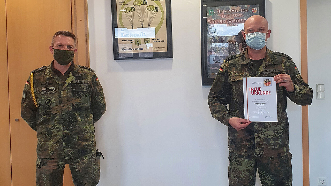 Oberstabsfeldwebel Frank Schmitt (l.) überreicht Oberstabsfeldwebel Jens Richter (r.) von der Luftlandeaufklärungskompanie 260 seine Urkunde zum 25. DBwV-Jubiläum. Foto: Timo Lauer