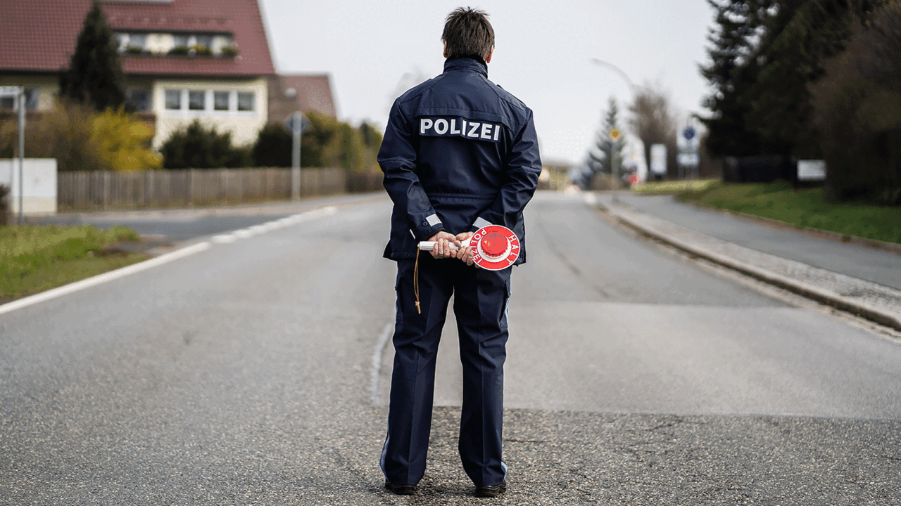 Bayern, Mitterteich: Ein Polizist kontrolliert die Ortsein- und ausfahrt von Mitterteich. Dort gilt bereits eine Ausgangssperre, weil die Zahl der am Coronavirus erkrankten Menschen besonders hoch ist. Foto: picture alliance/Nicolas Armer/dpa