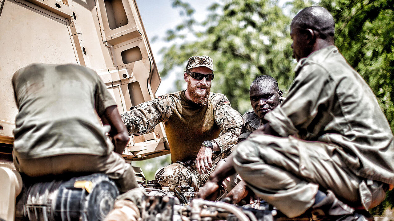 Ein Bundeswehrsoldat erklärt in der bei der Ausbildungsmission EUTM in Koulikoro Malischen Soldaten die Instandsetzung an einem LKW Foto: dpa