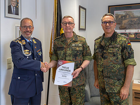 Stabsfeldwebel Volker Keil (links), Landesvorsitzender West und Oberstleutnant Michael Schwab (rechts), Bezirksvorsitzender, überreicheten Generalmajor Ansgar Meyer die Treueurkunde für 40 Jahre Mitgliedschaft im DBwV. Foto: Fw Reichel ZInFü