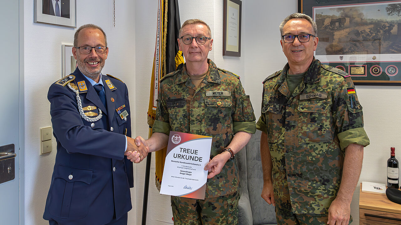 Stabsfeldwebel Volker Keil (links), Landesvorsitzender West und Oberstleutnant Michael Schwab (rechts), Bezirksvorsitzender, überreicheten Generalmajor Ansgar Meyer die Treueurkunde für 40 Jahre Mitgliedschaft im DBwV. Foto: Fw Reichel ZInFü