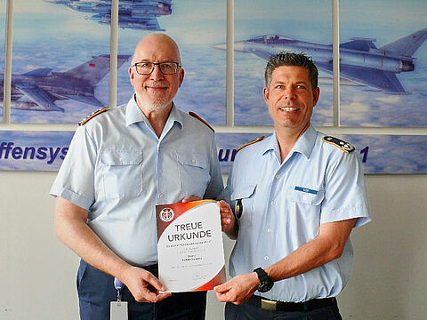 Oberst Ralf Kleindienst (l) erhielt von TruKa-Vorsitzendem Oberstleutnant Carsten Diers die Treueurkunde für 40-jährige Mitgliedschaft im BundeswehrVerband. Foto: TruKa Manching