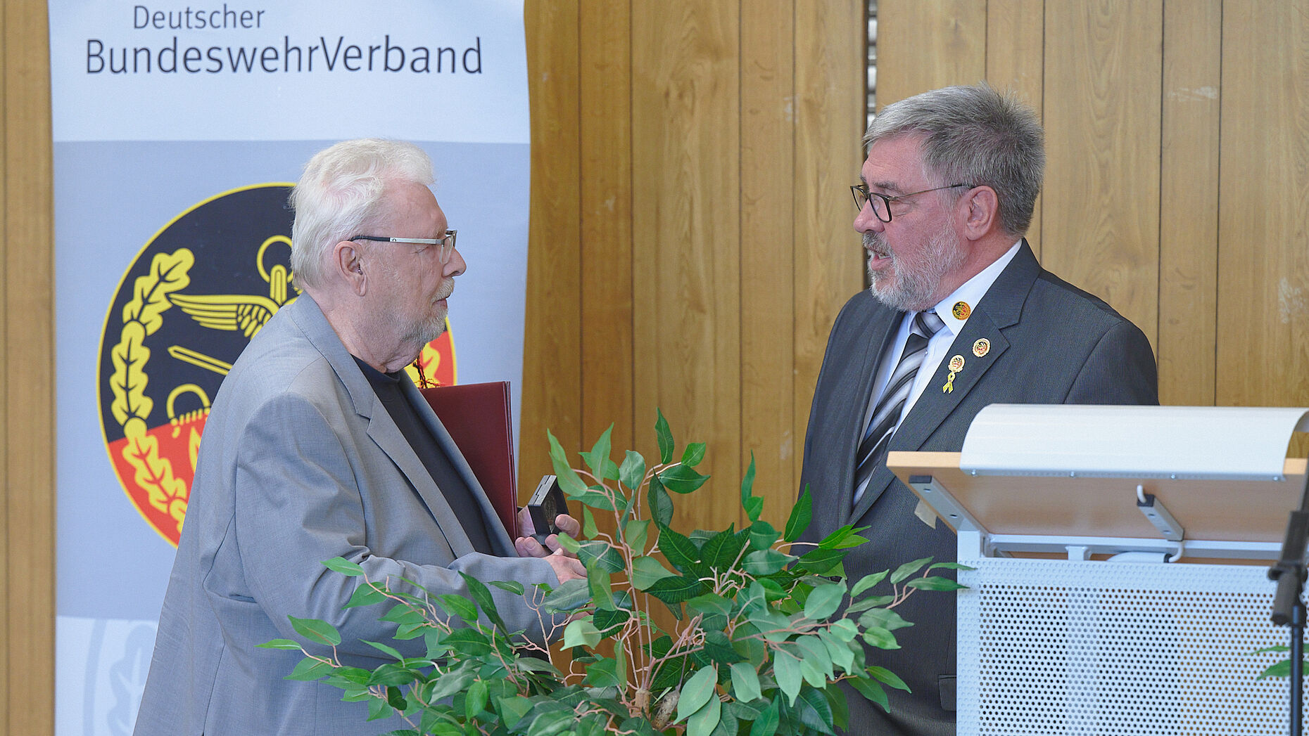 Als Zeichen der Anerkennung überreichte der Vorsitzende ERH Ernst Wendland dem Vorsitzenden Siegbert Schneider den „COIN ERH“ im Bundesvorstand. Foto: DBwV/ik