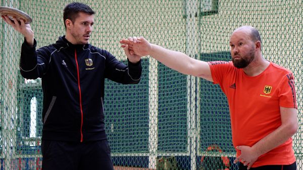 Ein Trainer erklärt Maik Mutschke, worauf er beim Diskuswerfen achten kann. Foto: DBwV/Sarina Flachsmeier