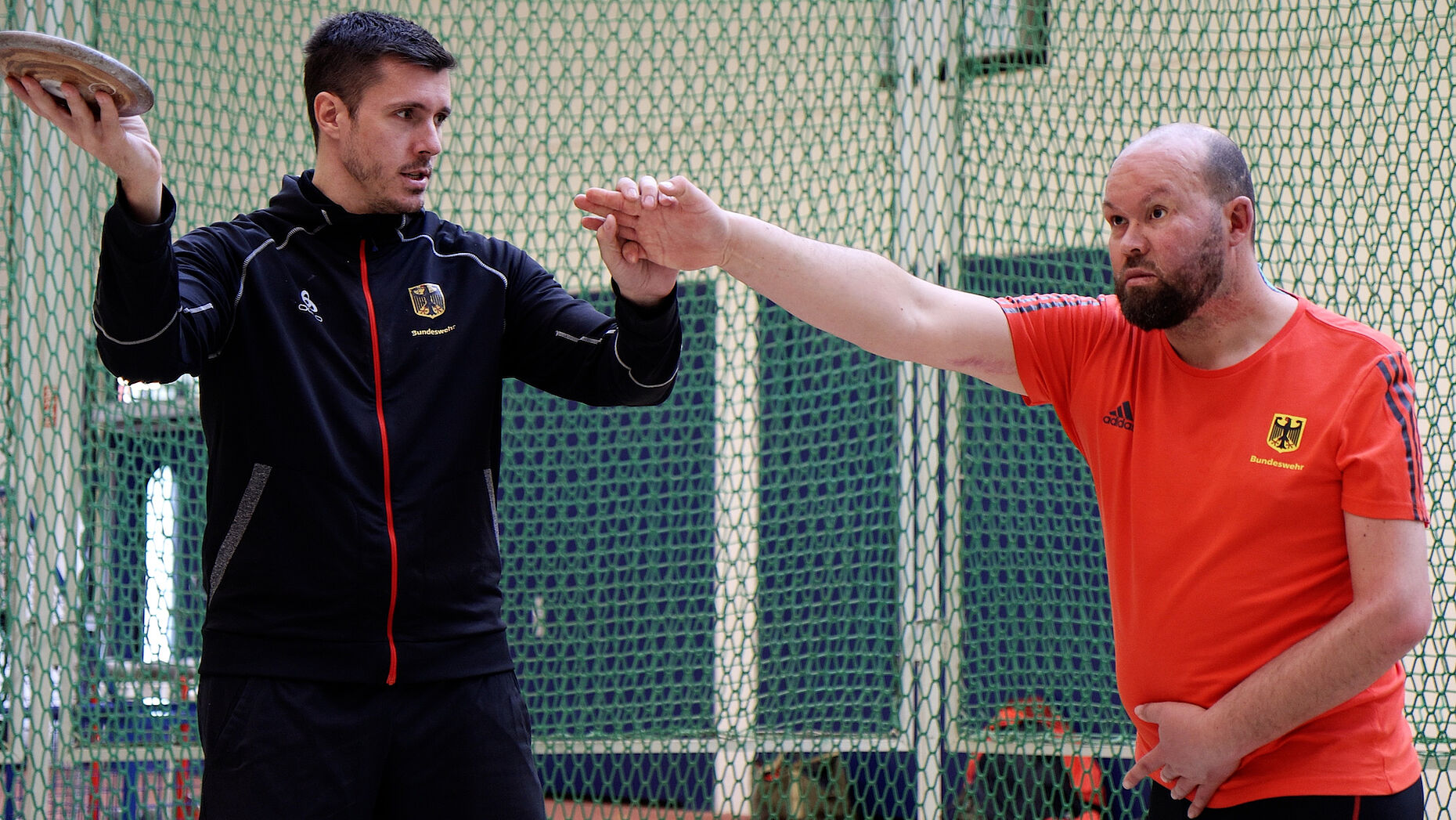 Ein Trainer erklärt Maik Mutschke, worauf er beim Diskuswerfen achten kann. Foto: DBwV/Sarina Flachsmeier
