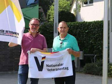Bernhard Esch (l.), Erster Beigeordneter der Stadt Lohmar und Rudolf Schmelzer, Ehrenmitglied des Deutschen BundeswehrVerbandes, hissen vor dem Rathaus die Flagge zum Nationalen Veteranentag am 15. Juni. Foto: Stadt Lohmar