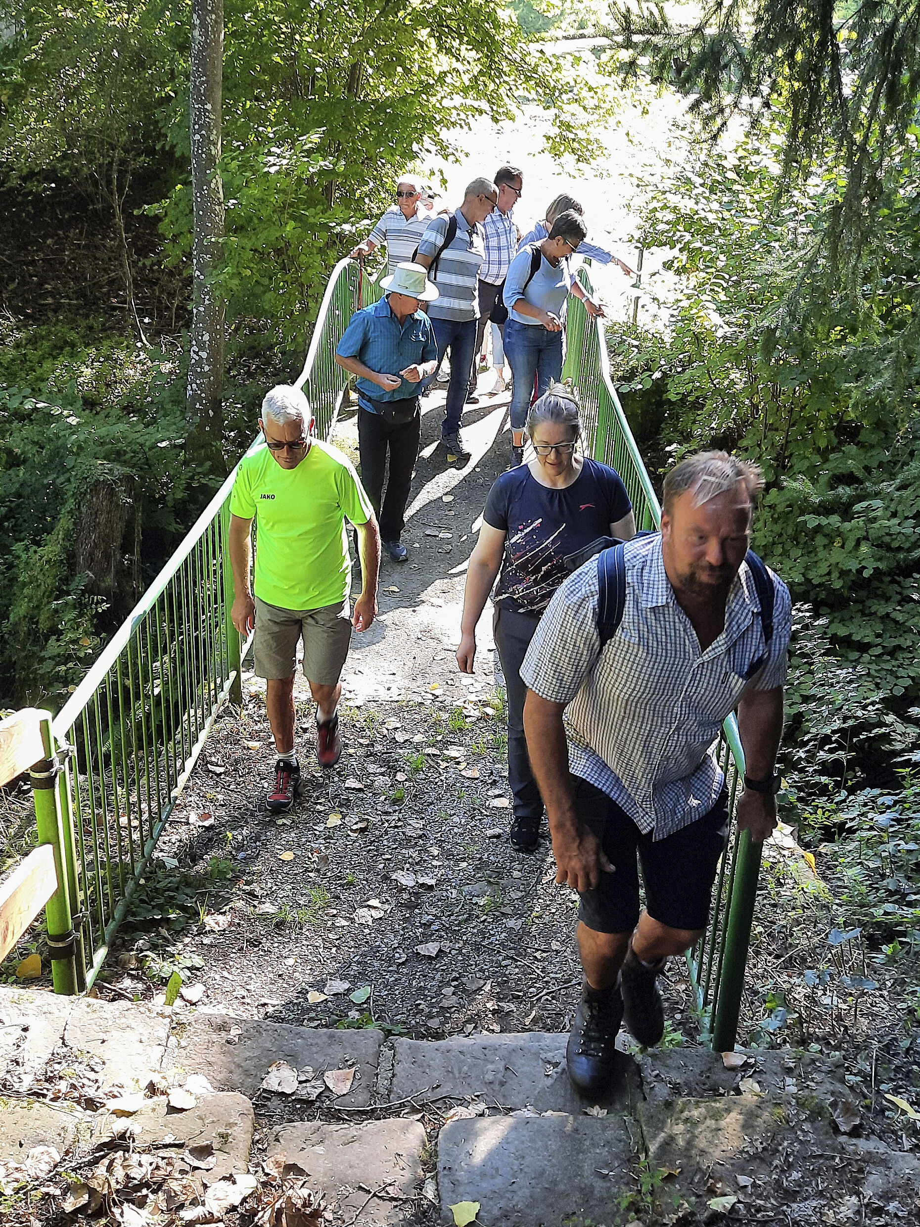 Angeführt von Bezirksvorsitzendem Gerd-Josef Bopp (v.r.) und Vorsitzendem Armin Rother überquert die Wandergruppe den Amorsbach. Foto: Carina Rother