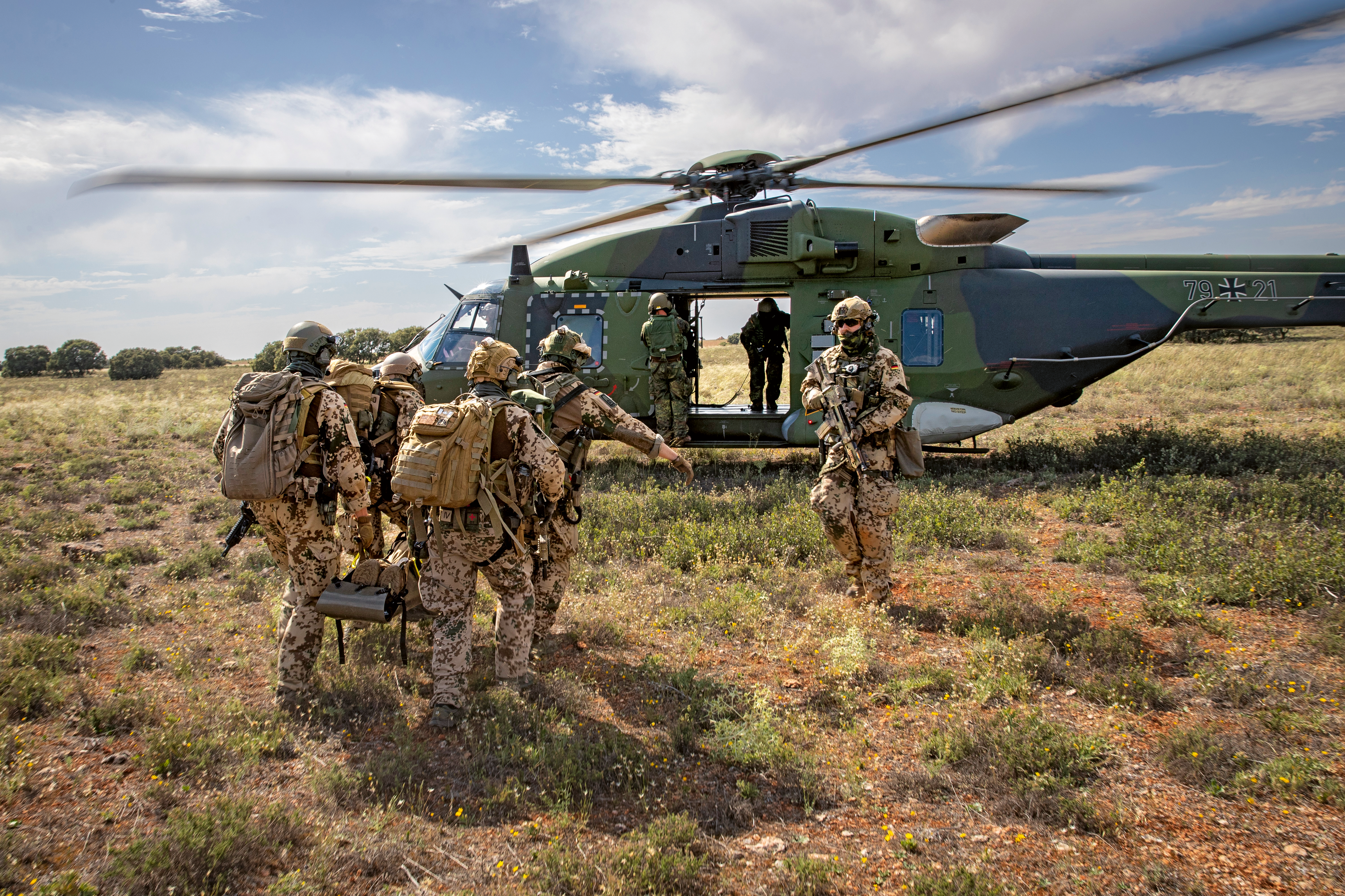 Kampfretter tragen bei einer NATO-Übung in Spanien einen Verwundeten auf einer Rolltrage zum Mehrzweckhubschrauber NH-90. Foto: Bundeswehr/Marc Tessensohn